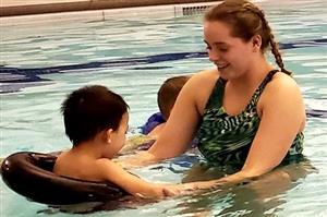 boy swimming with instructor