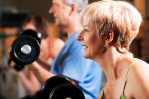Fit older couple lifting wieghts.